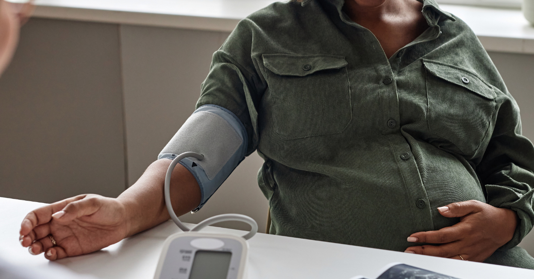Pregnant woman in green shirt measuring blood pressure following fertility guide after birth control