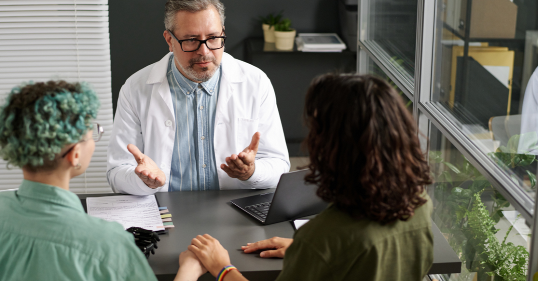 Couple consulting a doctor about how long to get pregnant after birth control in a medical office